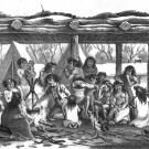 Alt text: Several Native Americans, mostly women and children, huddle around a cooking fire under a canopy made from logs, inside the fences of a settlement.