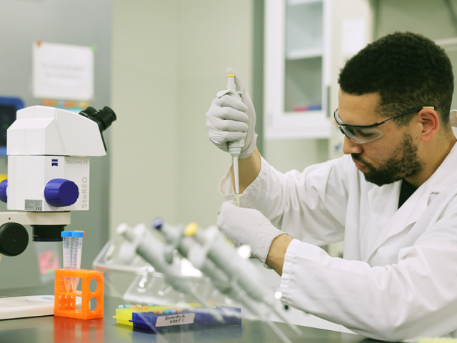 Man Titrating fluids in a lab.