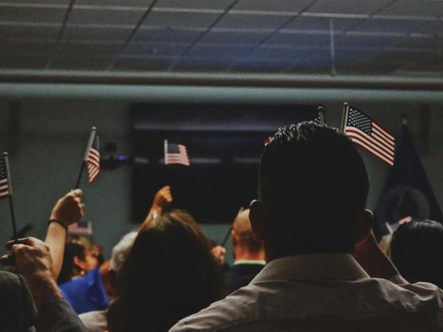 people in a dark room with american flags.