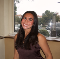 Smiling young woman in brown dress, indoor portrait photograph