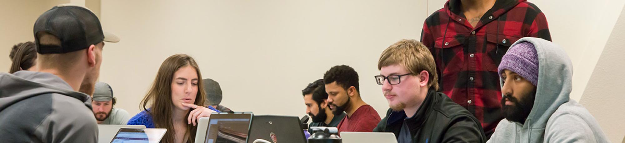 Instructor Nelly Sugira, standing to the right, helps students with a code-stringing exercise at UC Davis Extension's Coding Boot Camp. (Alex Ivaschenko/UC Davis Extension)